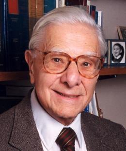 Head shot of man with white hair and glasses