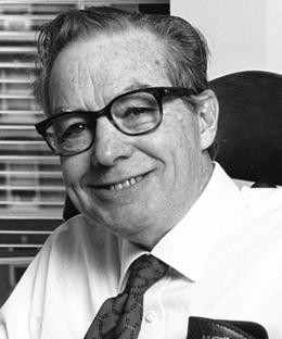 Black and white photo of man in tie wearing glasses