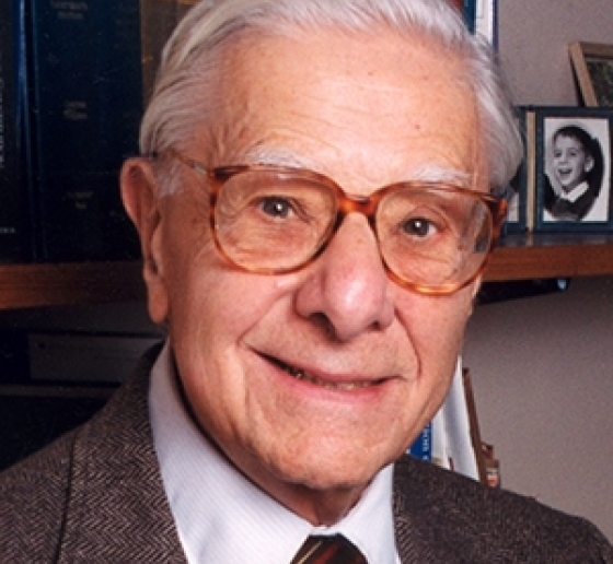 Head shot of man with white hair and glasses