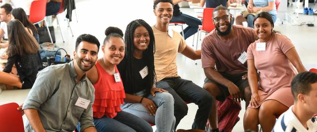 Six 1L law students smile in a sun-filled atrium.