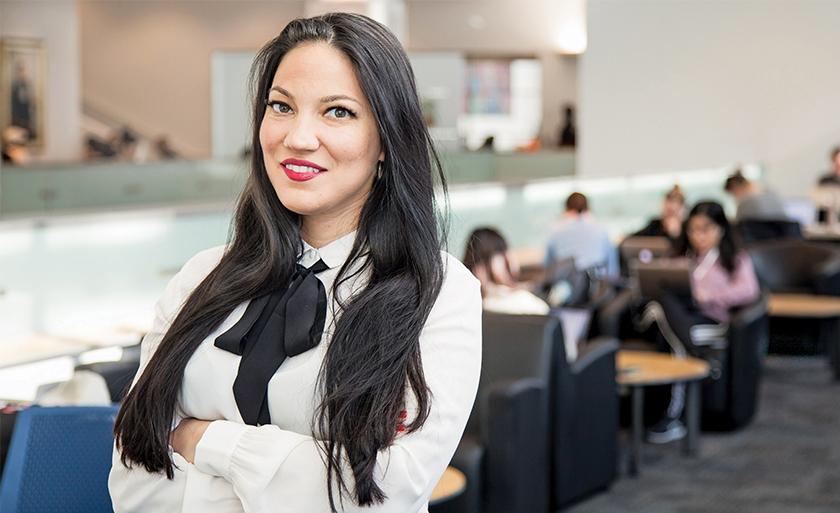A women in business attire smiles.